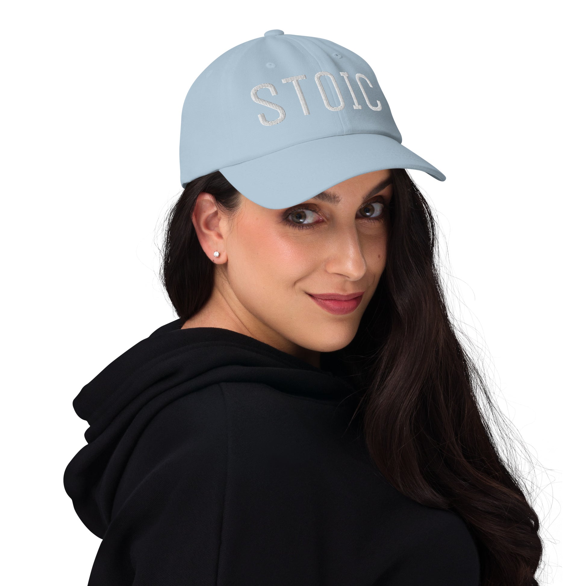 Light blue stoic embroidered dad hat on woman with black hoodie